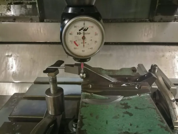 Imagen de un proceso de búsqueda cero con pínula, usando una mordaza biaxial para el mecanizado de una pieza, con dos ángulos en un centro de fresado de 3 ejes